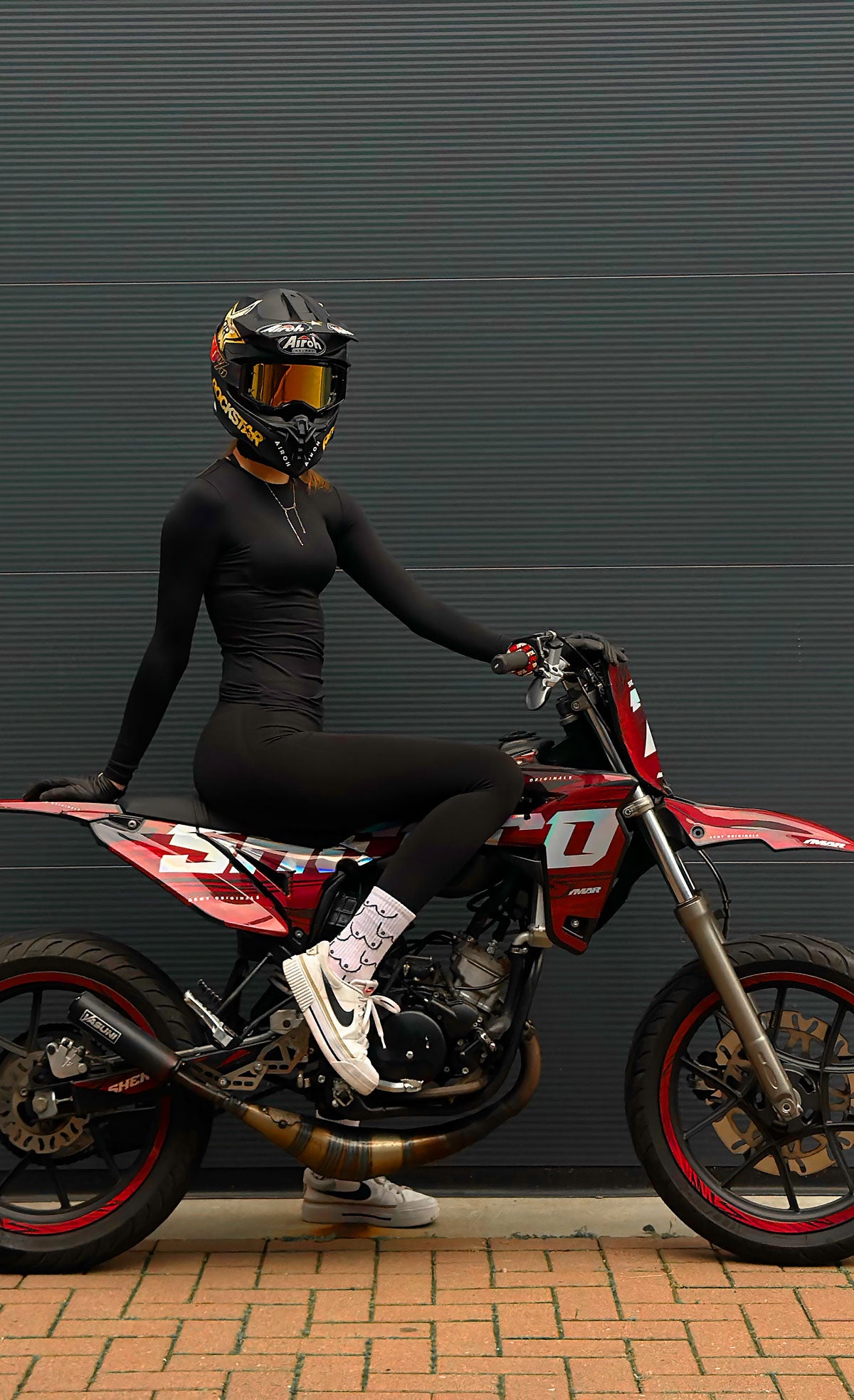 kit déco holographique de coloris bordeaux pour SHerco 50cc. Une personne est installé sur la moto vu de profil.